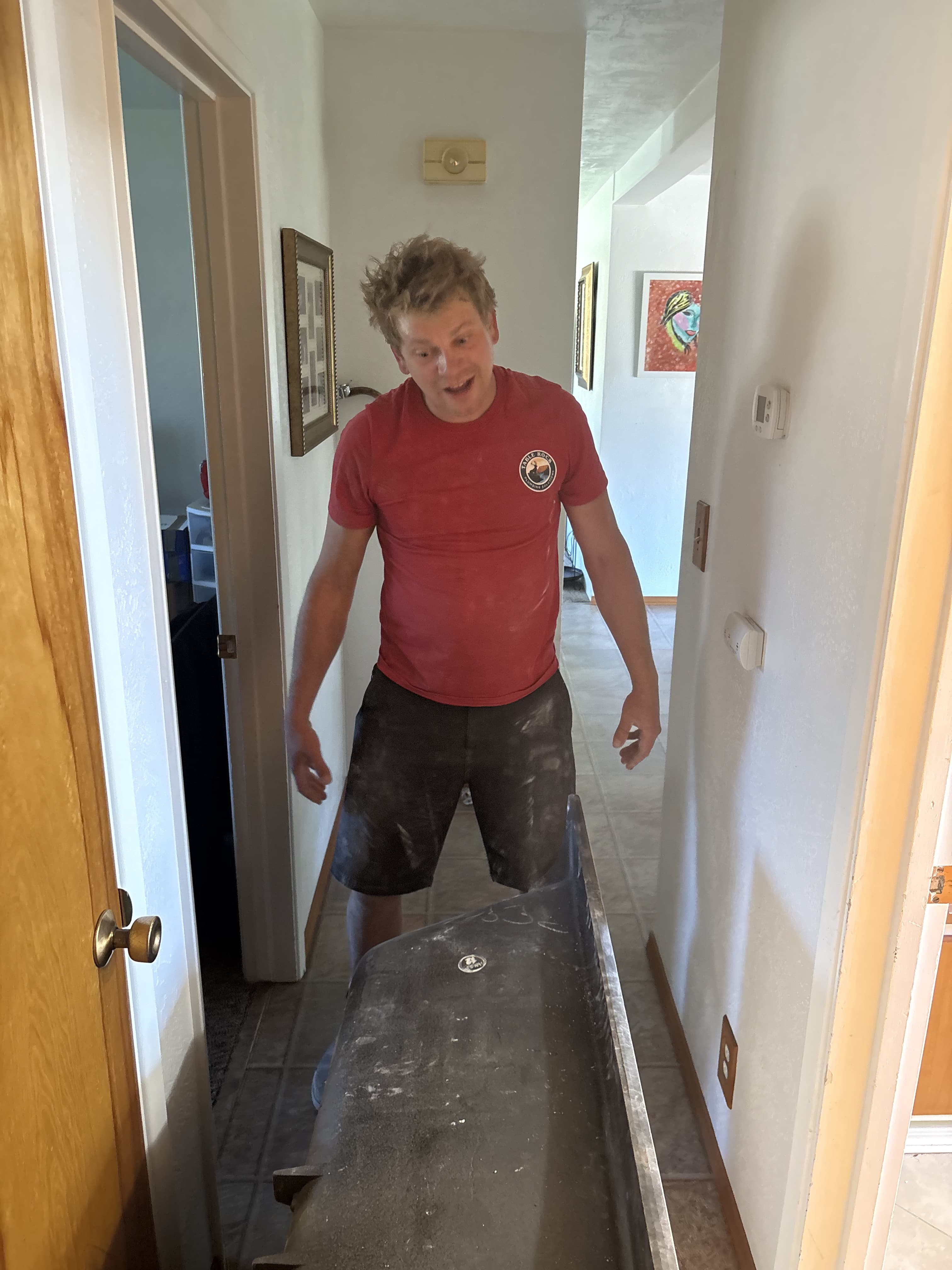 Table Rock Plumbing technician moving an old plumbing fixture through a home