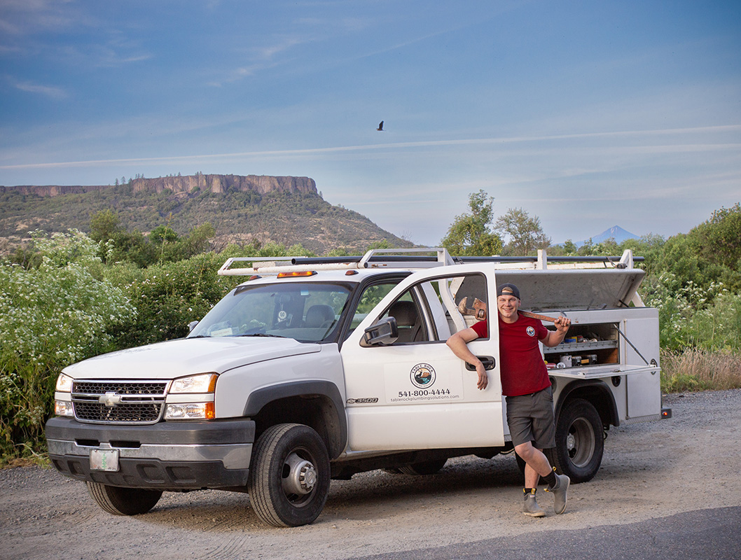 Table Rock Plumbing Solutions truck and an employee with Table Rock rising behind them in Southern Oregon